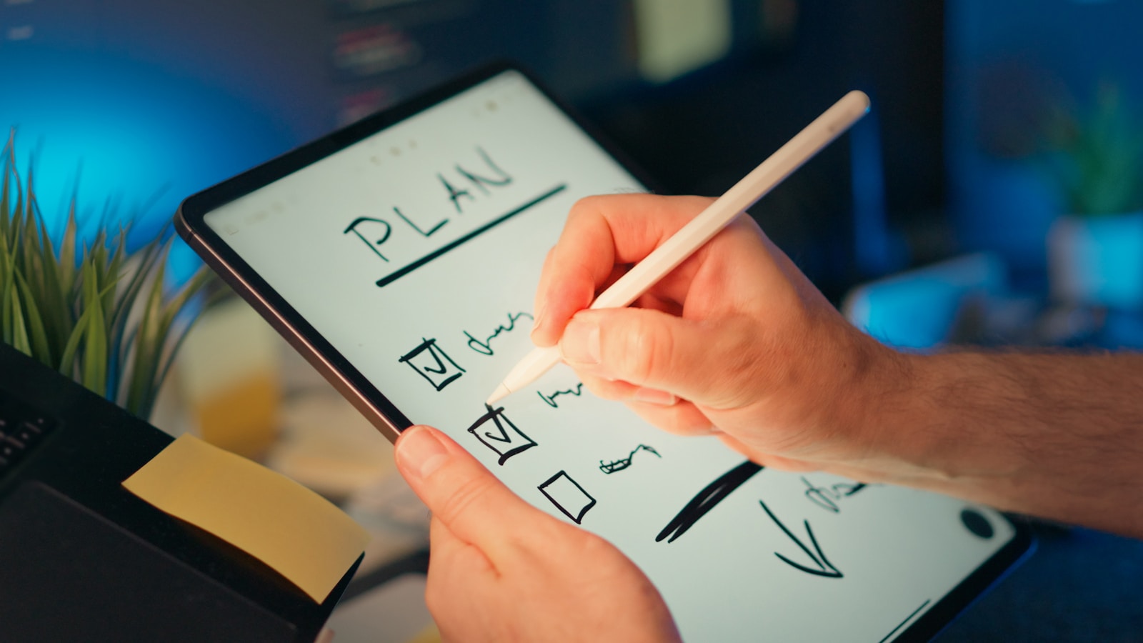 Person writing a digital roadmap and checklist on a tablet